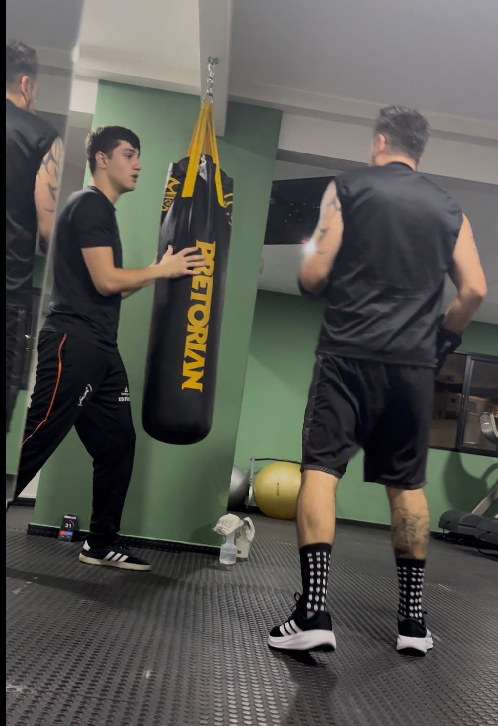 J. Gabriel orientando aluno em aula individual no saco de pancadas